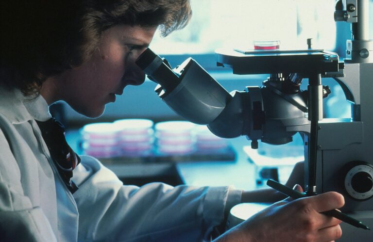 Scientist looking through a microscope in a research laboratory